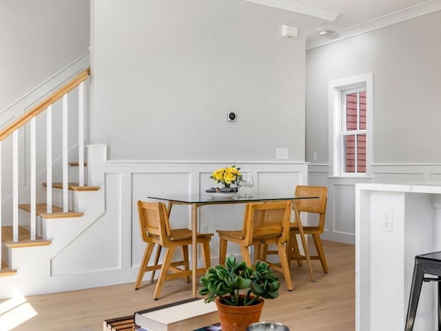 dining area with light hardwood / wood-style floors and ornamental molding