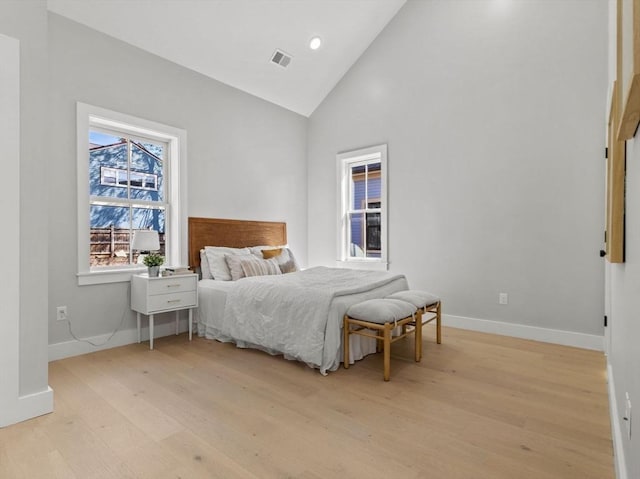 bedroom with high vaulted ceiling and light hardwood / wood-style floors