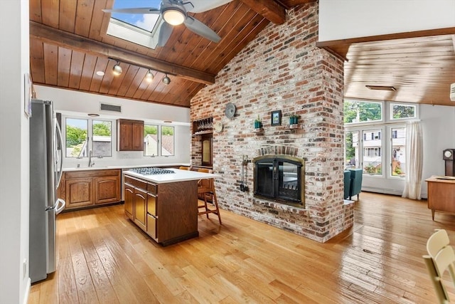 27 Johnson St, Malden, MA 02148 - kitchen with freestanding refrigerator, a fireplace, a ceiling fan, light wood-style floors, and light countertops
