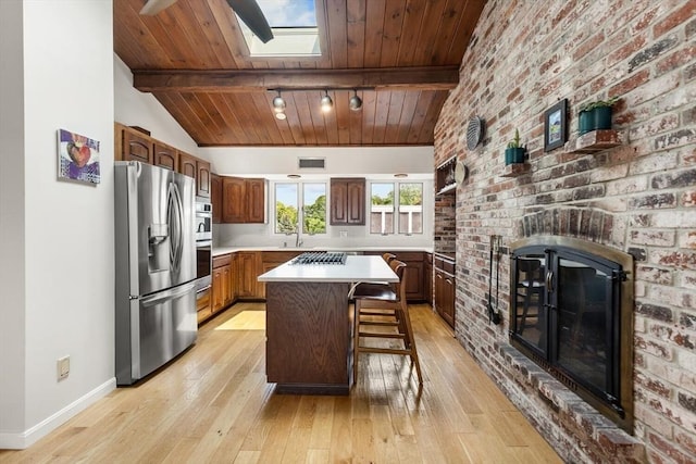 27 Johnson St, Malden, MA 02148 - kitchen featuring stainless steel refrigerator with ice dispenser, a brick fireplace, light wood finished floors, light countertops, and wood ceiling