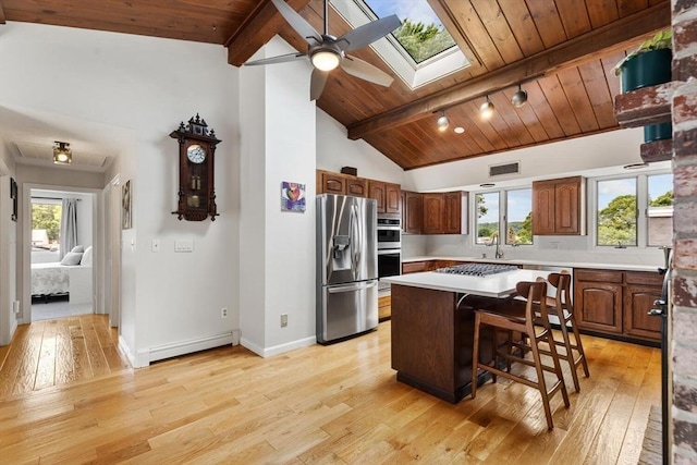 27 Johnson St, Malden, MA 02148 - kitchen featuring stainless steel appliances, a baseboard radiator, wooden ceiling, light countertops, and light wood finished floors