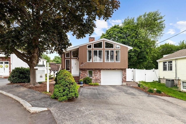 27 Johnson St, Malden, MA 02148 - view of front facade featuring a gate, asphalt driveway, a chimney, brick siding, and a garage