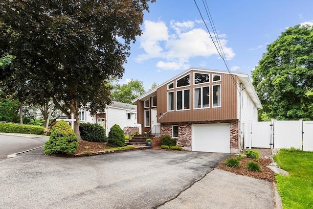 27 Johnson St, Malden, MA 02148 - view of front facade with a gate, driveway, an attached garage, and brick siding
