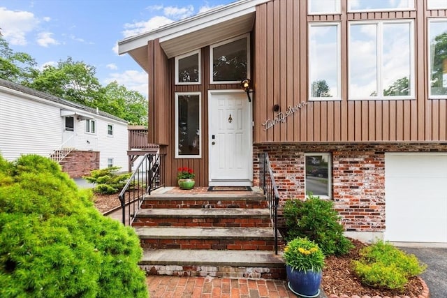 27 Johnson St, Malden, MA 02148 - property entrance with board and batten siding, a garage, and brick siding
