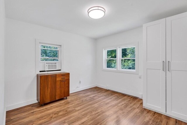 2 Clover Hill Rd, Acton, MA 01720 - unfurnished bedroom with multiple windows, light wood-type flooring, cooling unit, and a baseboard heating unit