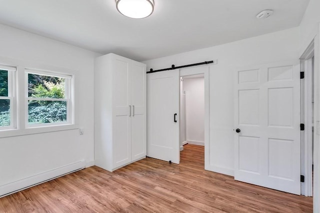 2 Clover Hill Rd, Acton, MA 01720 - unfurnished bedroom with a barn door and light wood-type flooring