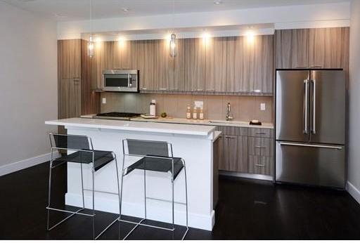 kitchen with decorative light fixtures, appliances with stainless steel finishes, sink, tasteful backsplash, and a breakfast bar area