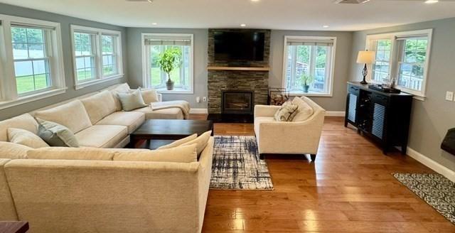 214 Fisher St, Walpole, MA 02081 - living room with healthy amount of natural light, wood finished floors, a stone fireplace, and recessed lighting