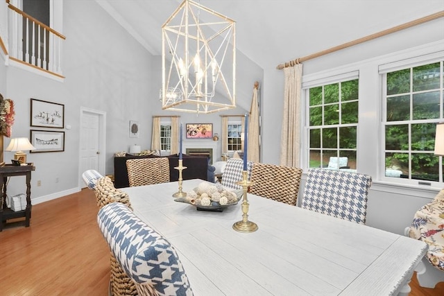 10 Highcroft Way Unit 10, Hopkinton, MA 01748 - dining area featuring a chandelier, high vaulted ceiling, wood finished floors, a fireplace, and baseboards