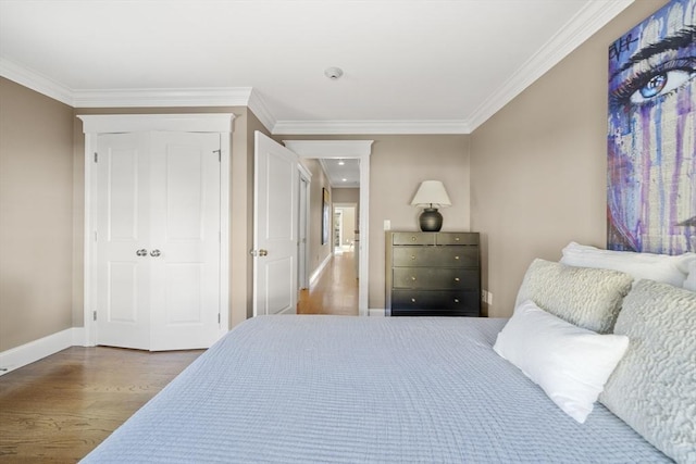 bedroom with baseboards, wood finished floors, and crown molding