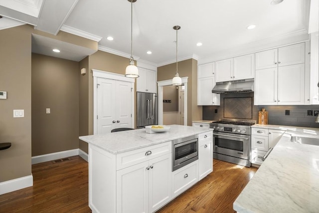 kitchen featuring backsplash, a kitchen island, baseboards, under cabinet range hood, and high end appliances