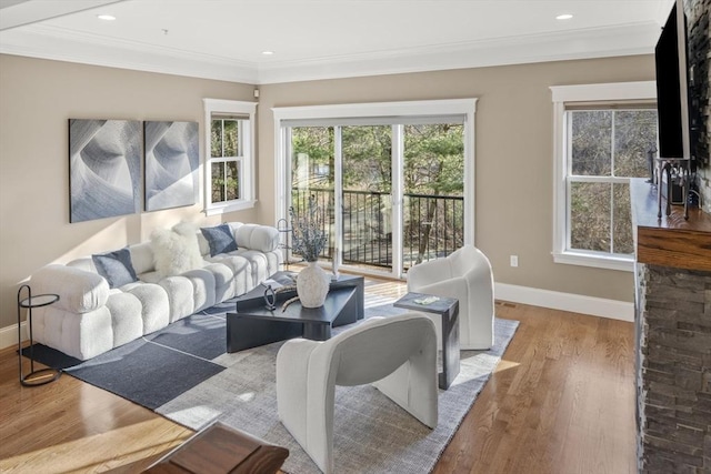 living area featuring recessed lighting, baseboards, wood finished floors, and crown molding