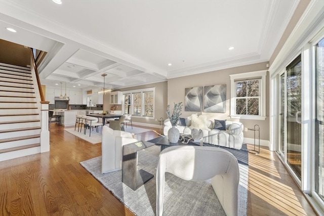 living area with stairs, beam ceiling, recessed lighting, wood finished floors, and coffered ceiling