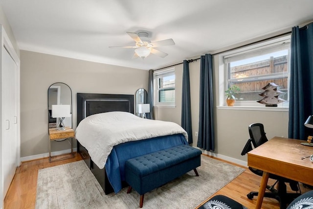 bedroom with a ceiling fan, baseboards, and wood finished floors