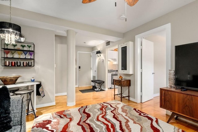 interior space with light wood-style floors, baseboards, visible vents, and a notable chandelier