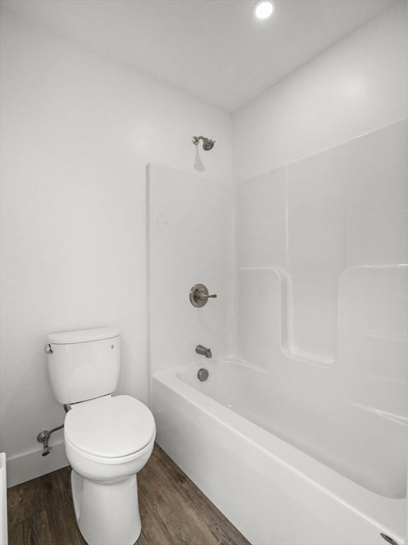 bathroom featuring bathing tub / shower combination, wood-type flooring, and toilet