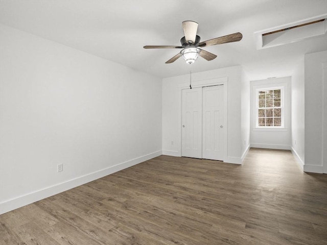 unfurnished bedroom with ceiling fan, dark wood-type flooring, and a closet