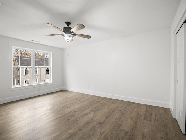 unfurnished bedroom featuring a closet, hardwood / wood-style flooring, and ceiling fan