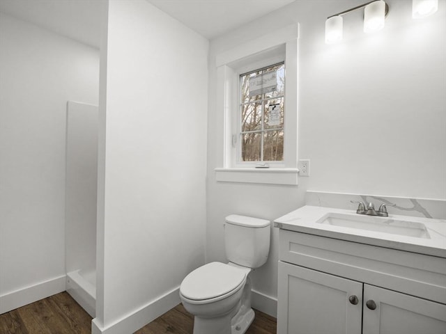 bathroom featuring a shower, wood-type flooring, vanity, and toilet