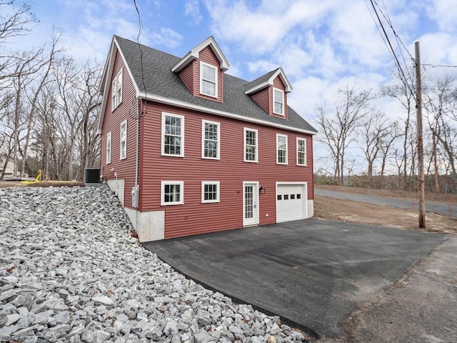 view of property exterior featuring central AC and a garage