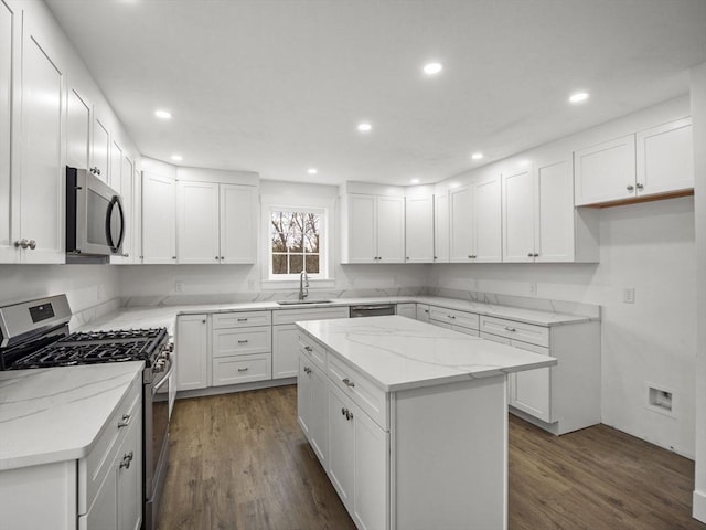 kitchen featuring a center island, white cabinetry, sink, and appliances with stainless steel finishes