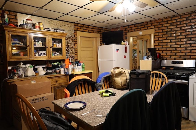 dining space featuring ceiling fan and brick wall