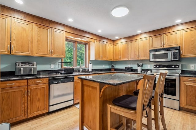 32 Berkeley, Pelham, NH 03076 - kitchen with stainless steel appliances, light wood-type flooring, brown cabinetry, a kitchen island, and recessed lighting