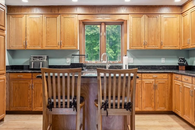 32 Berkeley, Pelham, NH 03076 - kitchen featuring light wood finished floors, recessed lighting, brown cabinetry, and dark stone counters
