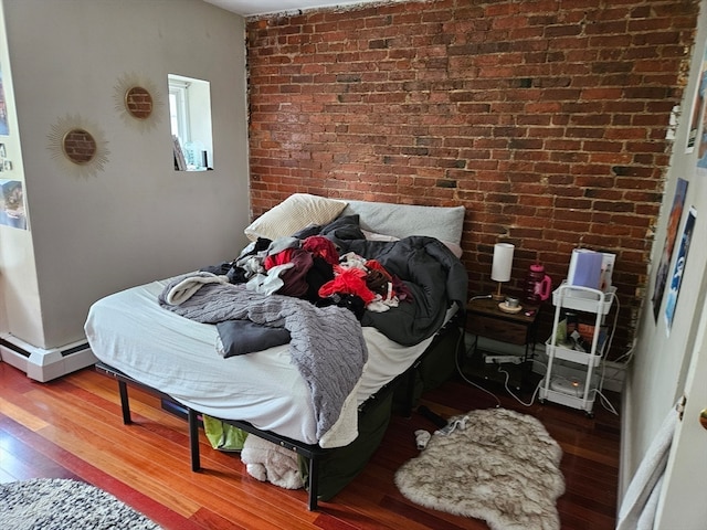 bedroom with brick wall and hardwood / wood-style floors