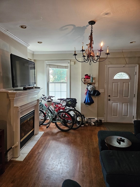 interior space with crown molding, wood-type flooring, and an inviting chandelier