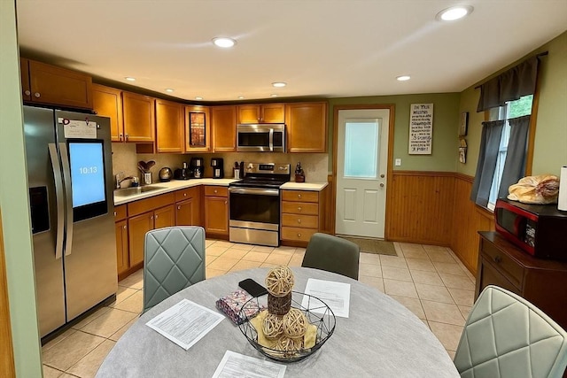 22 Sylvia Ave, Brockton, MA 02301 - kitchen featuring stainless steel appliances, light tile patterned floors, light countertops, wainscoting, and wood walls