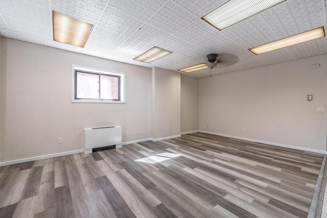 unfurnished room featuring a ceiling fan, wood finished floors, and baseboards