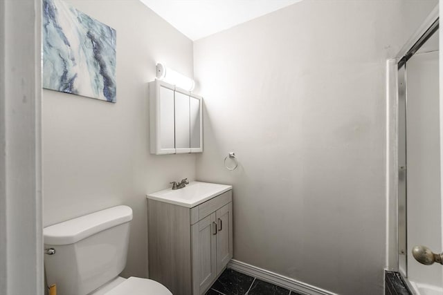 bathroom with vanity, toilet, and baseboards