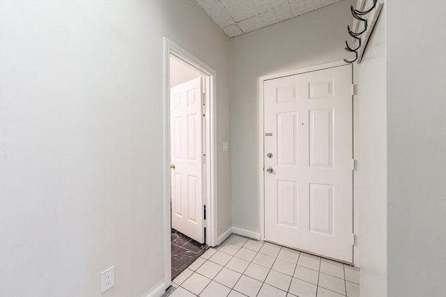 interior space featuring light tile patterned flooring and baseboards