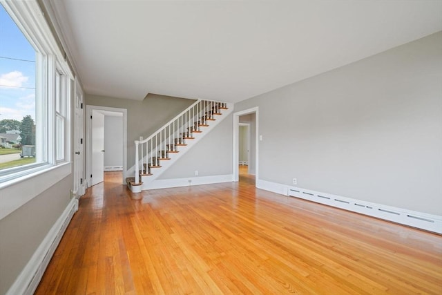 13 Meadow Ln, Acushnet, MA 02743 - unfurnished living room featuring stairway, light wood-type flooring, a baseboard heating unit, and baseboard heating