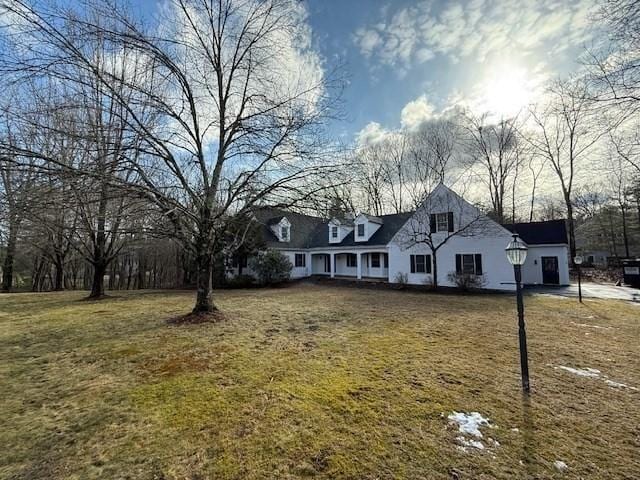 cape cod house with a front yard