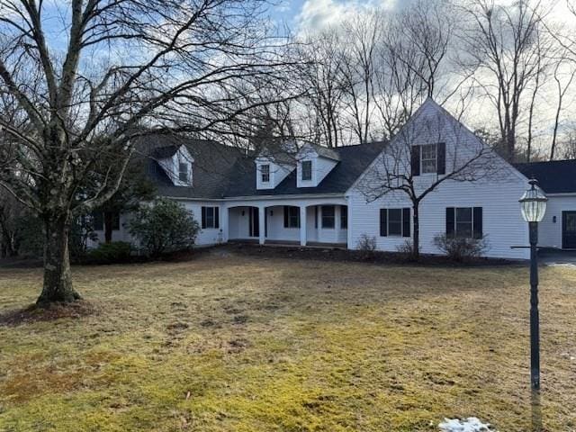 cape cod house with a front yard