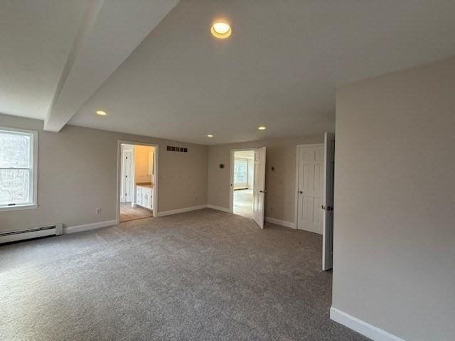 carpeted empty room featuring a baseboard radiator and beamed ceiling