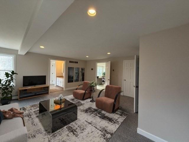 carpeted living room featuring beamed ceiling