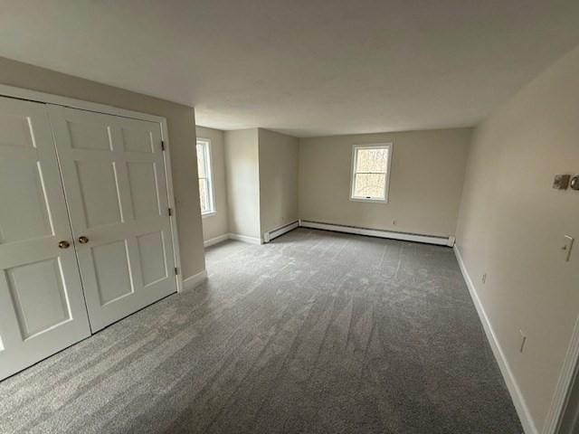 carpeted spare room featuring baseboard heating