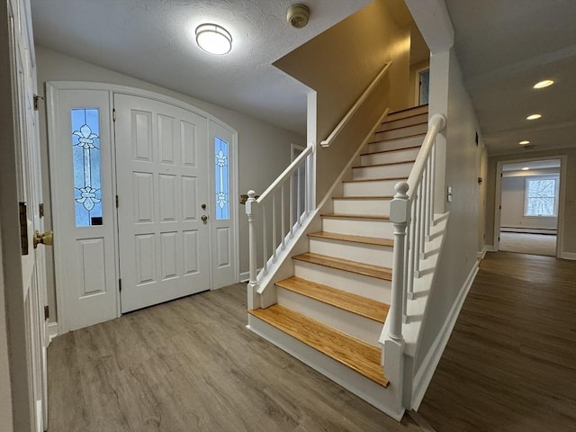 foyer entrance featuring hardwood / wood-style floors and a textured ceiling