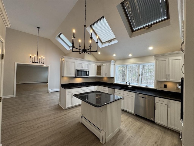 kitchen with a baseboard heating unit, hanging light fixtures, a center island, and appliances with stainless steel finishes