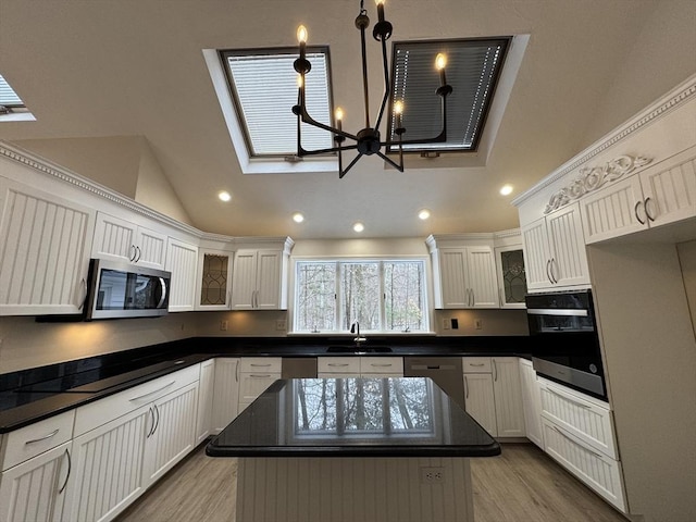 kitchen featuring white cabinetry, stainless steel appliances, sink, and a kitchen island