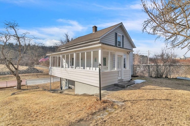 view of home's exterior featuring a sunroom and a lawn