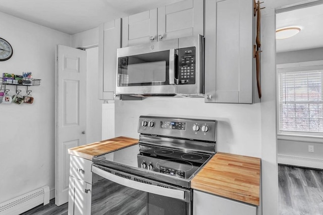 kitchen with stainless steel appliances, a baseboard heating unit, and dark wood-type flooring