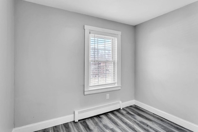 spare room with wood-type flooring and a baseboard radiator