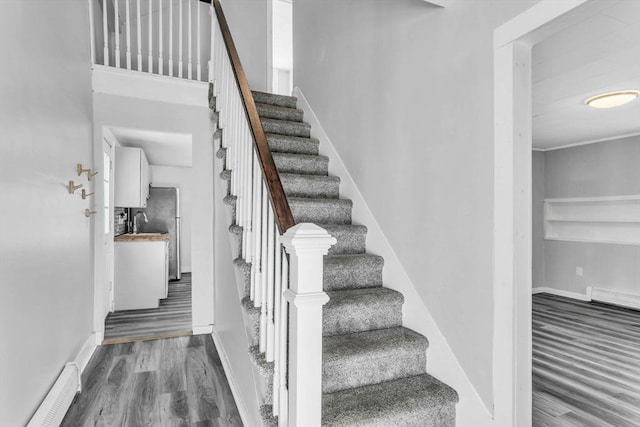 stairs featuring sink and hardwood / wood-style floors