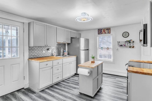 kitchen with a healthy amount of sunlight, wooden counters, and sink