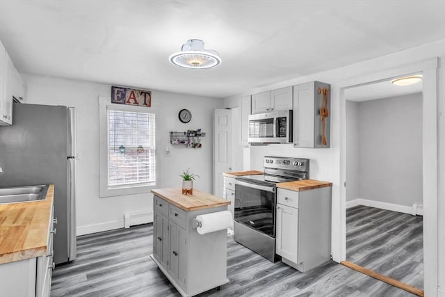 kitchen featuring appliances with stainless steel finishes, wood counters, and wood-type flooring