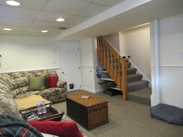 carpeted living room with a drop ceiling